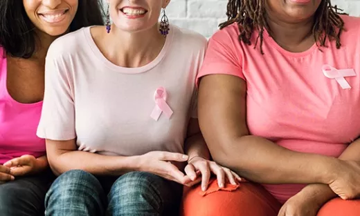 Women wearing pink shirts and breast cancer ribbons